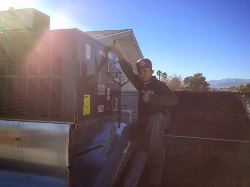 HVAC technician performing HVAC Inspection on a rooftop unit in Bayville
